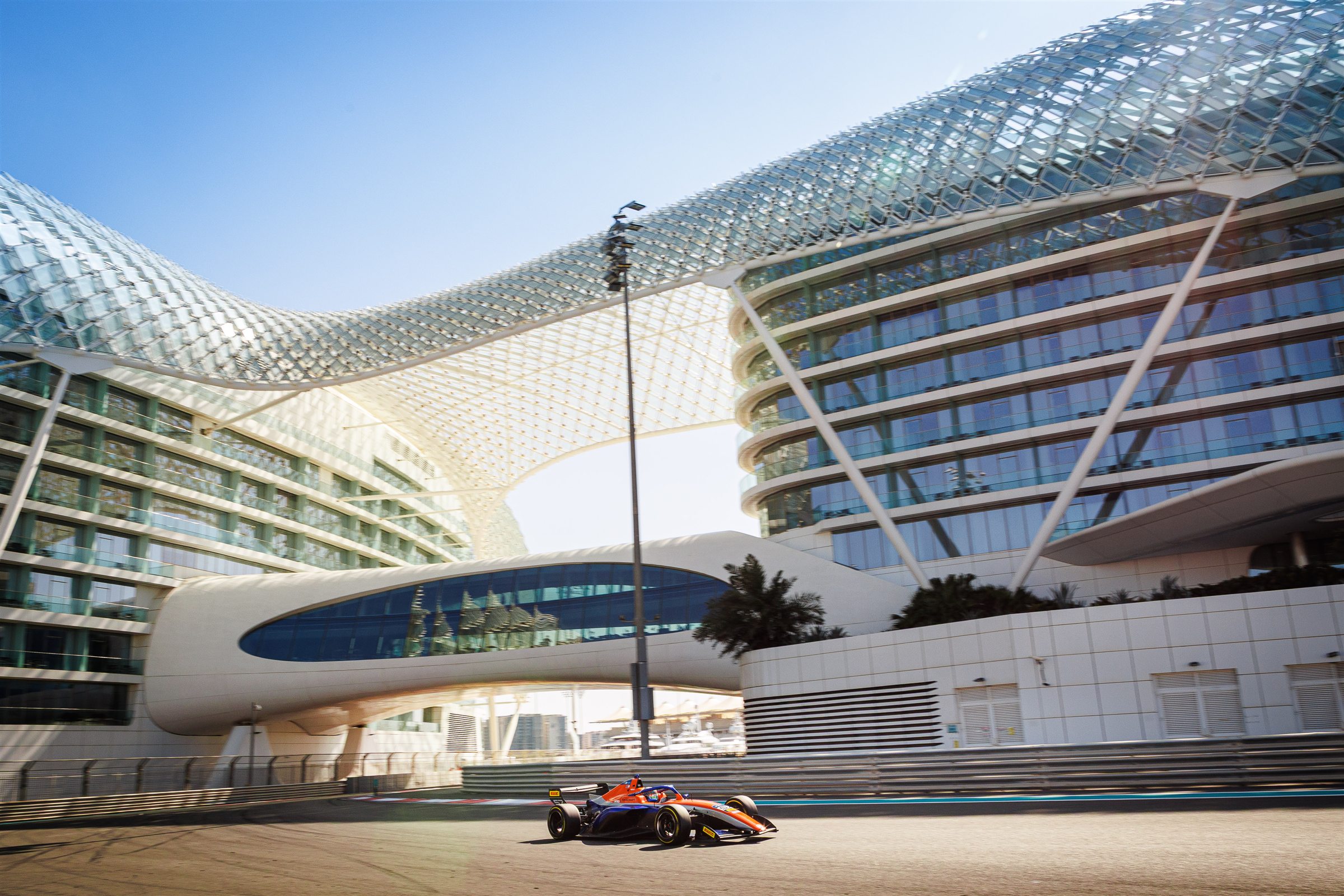 A Formula-style race car speeding past the W Abu Dhabi hotel on Yas Marina Circuit