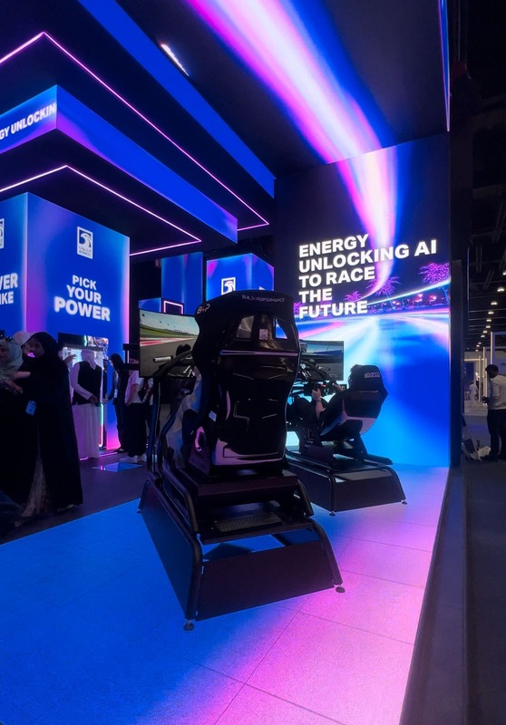 Racecraft simulator rigs glowing under blue and pink neon lighting at a brand activation booth