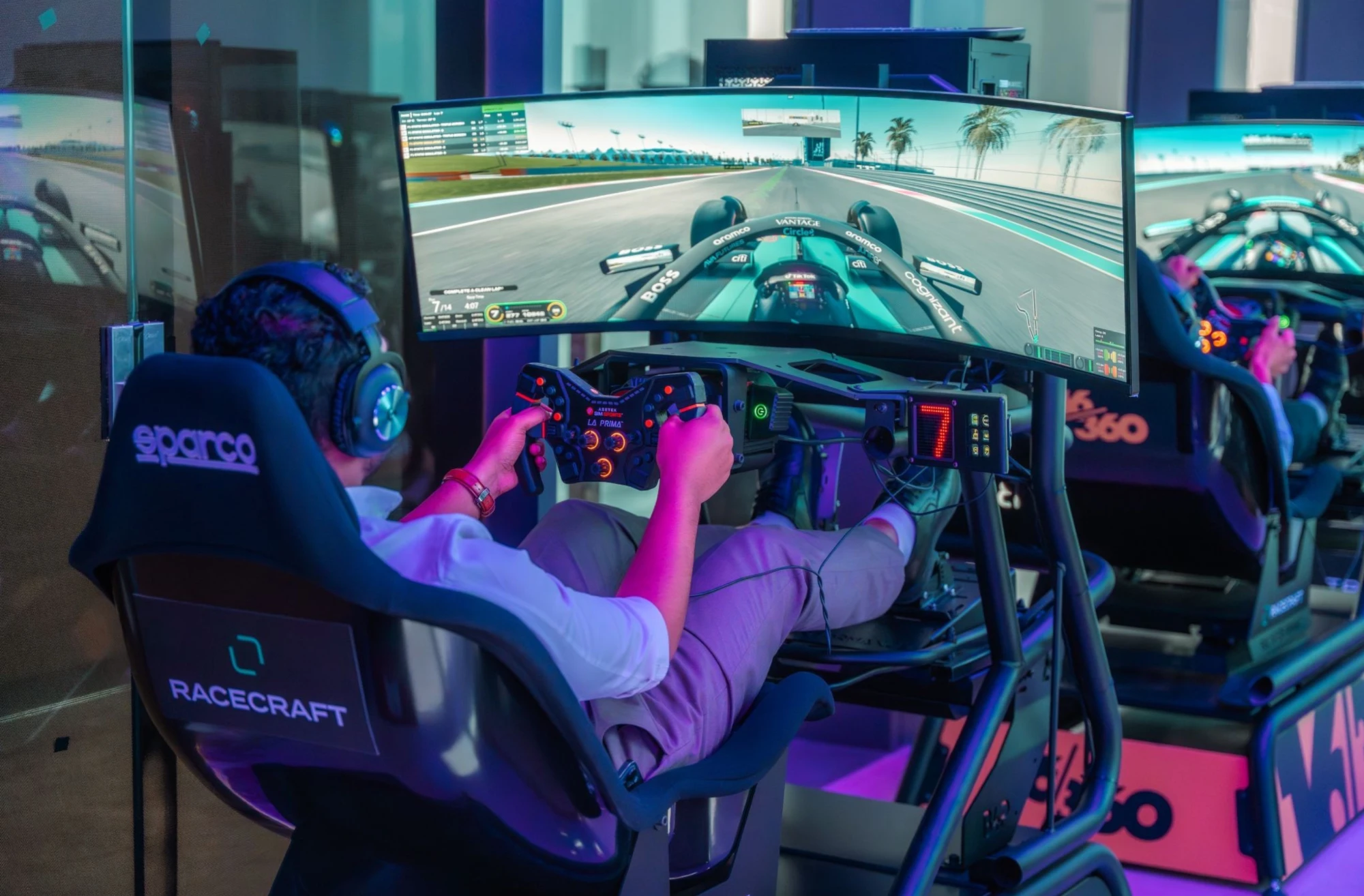A guest racing on a Racecraft simulator with a curved screen